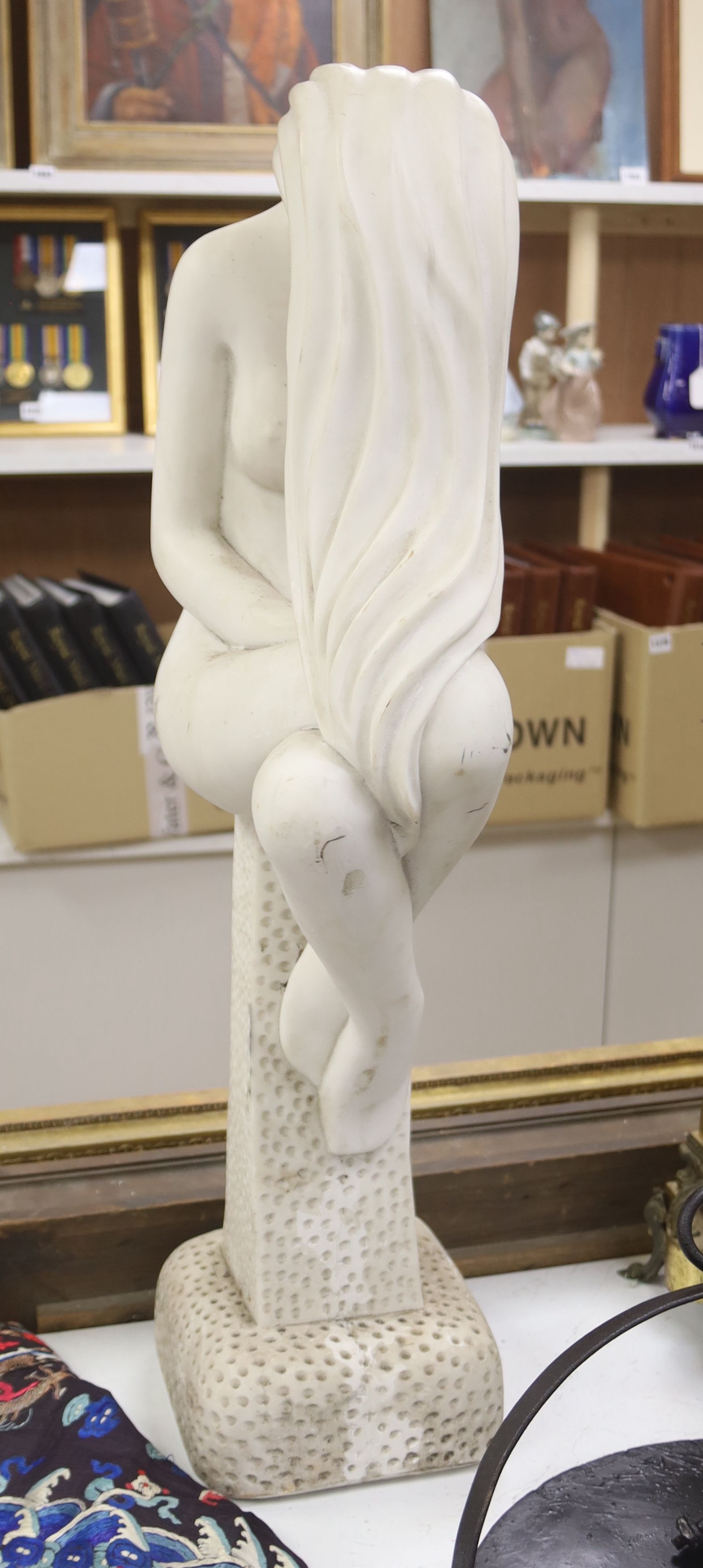 A faux marble figure of a seated nude, on plinth, height 81cm